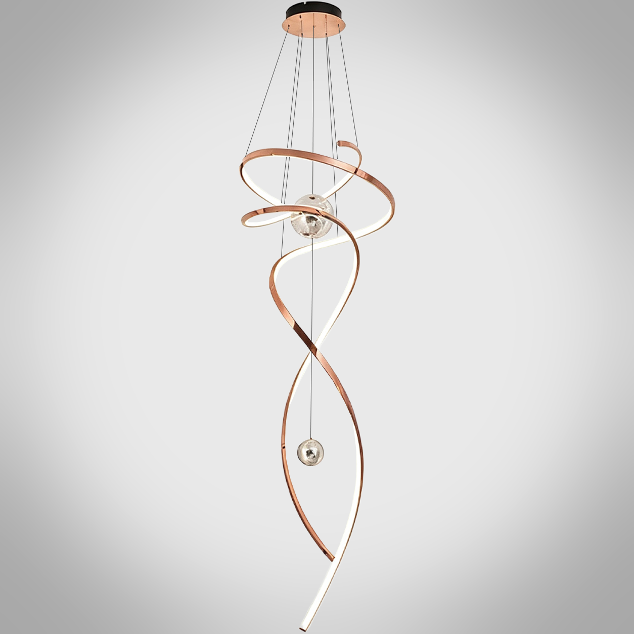 Modern rose gold stainless steel helical helix LED wave pendant light with floating orb spheres suspended in a high ceiling foyer