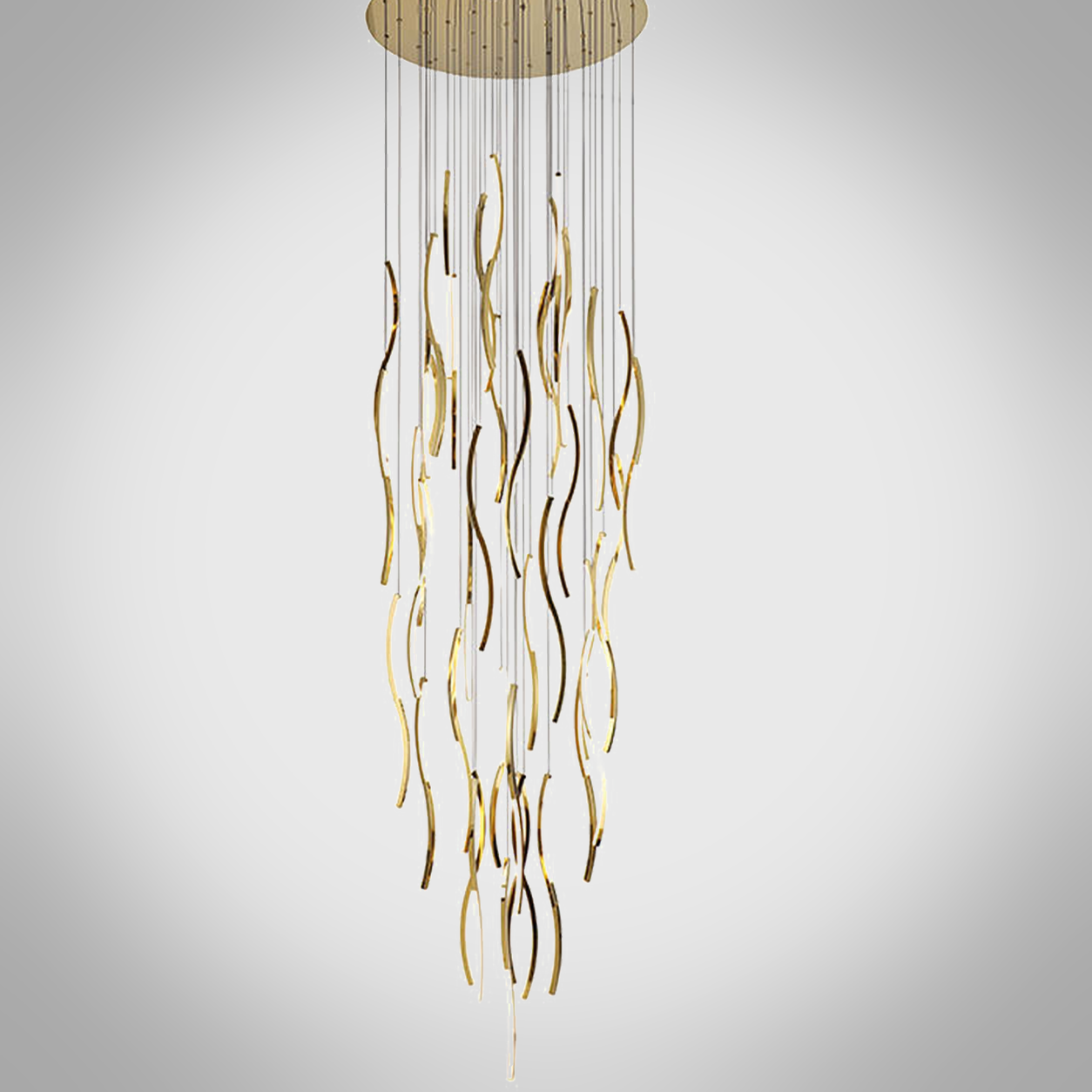Modern gold polished stainless steel wave streamer raindrop chandelier suspended in a high ceiling villa foyer