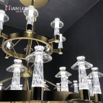 Detailed view of brushed brass stainless steel frame and precision crystal column shades on a luxury multi-tiered chandelier