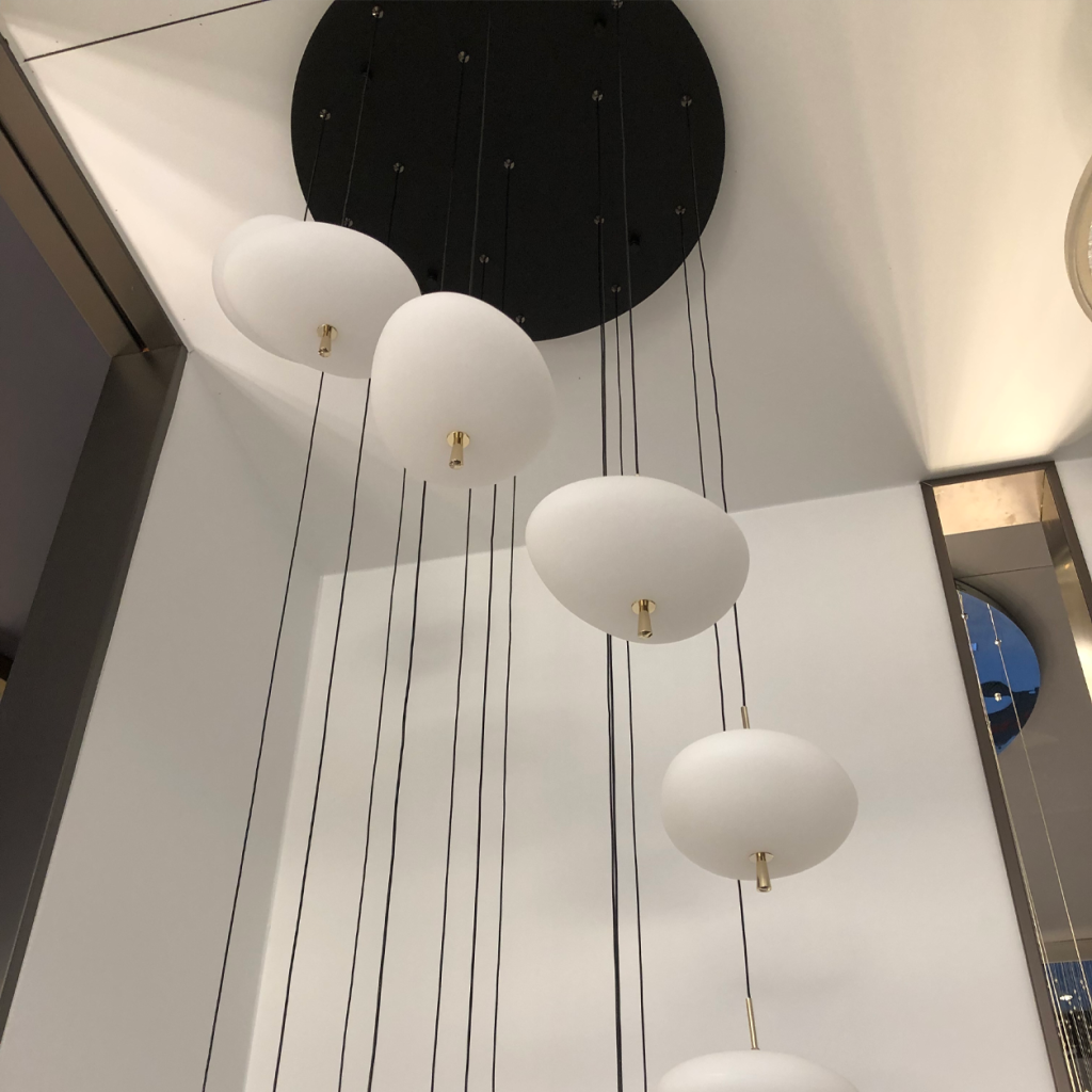 Close-up of frosted optical acrylic pebble light pods on a cold-rolled steel black canopy plate