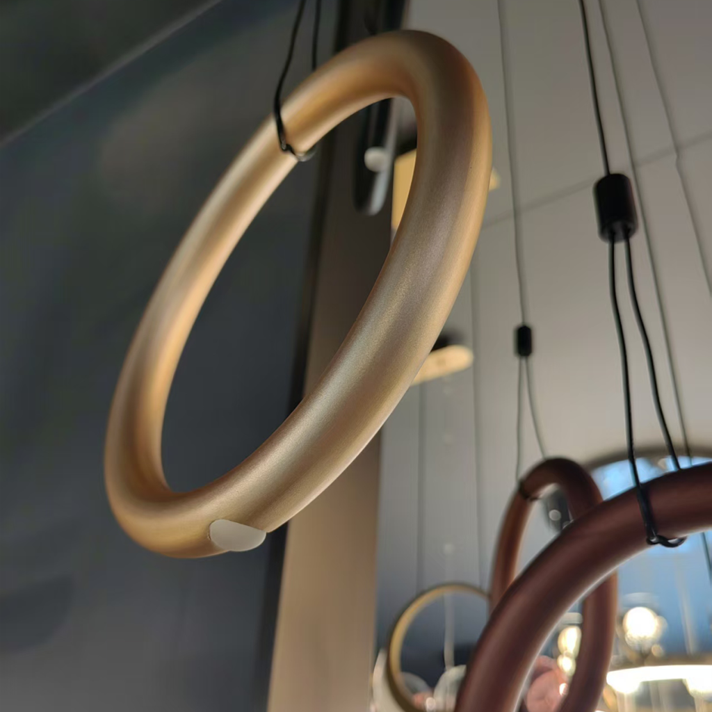 Close-up of terracotta bronze aluminum hoop ring showing smooth matte texture and suspension cable attachment