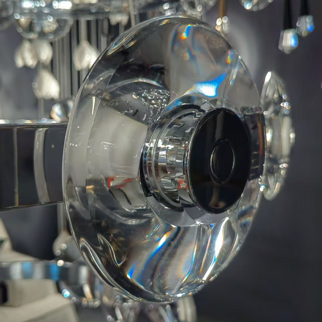 Close-up of thick optical crystal lens disc with halo LED lighting on a mirror chrome ring chandelier