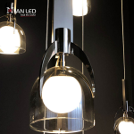 Close-up of double-layer glass shade, marble block, and mirror brown stainless steel arch frame on a luxury pendant chandelier