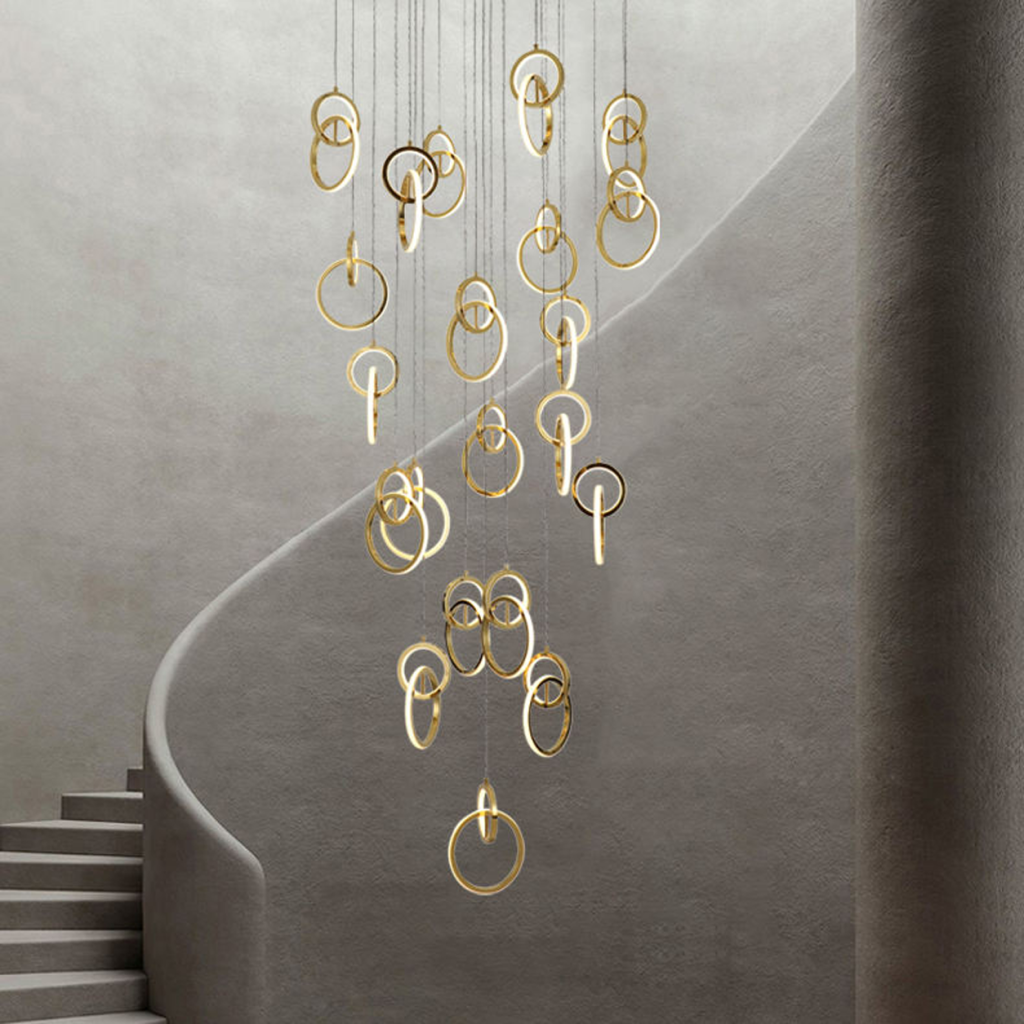 Modern gold stainless steel interlocking ring cascade chandelier suspended in a high ceiling villa foyer