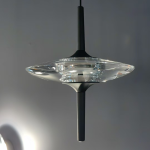 Close-up of UFO spinning-top crystal pendant light featuring optical crystal disc and matte black aluminum stem