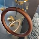 Close-up of terracotta bronze aluminum hoop ring showing smooth matte texture and suspension cable attachment