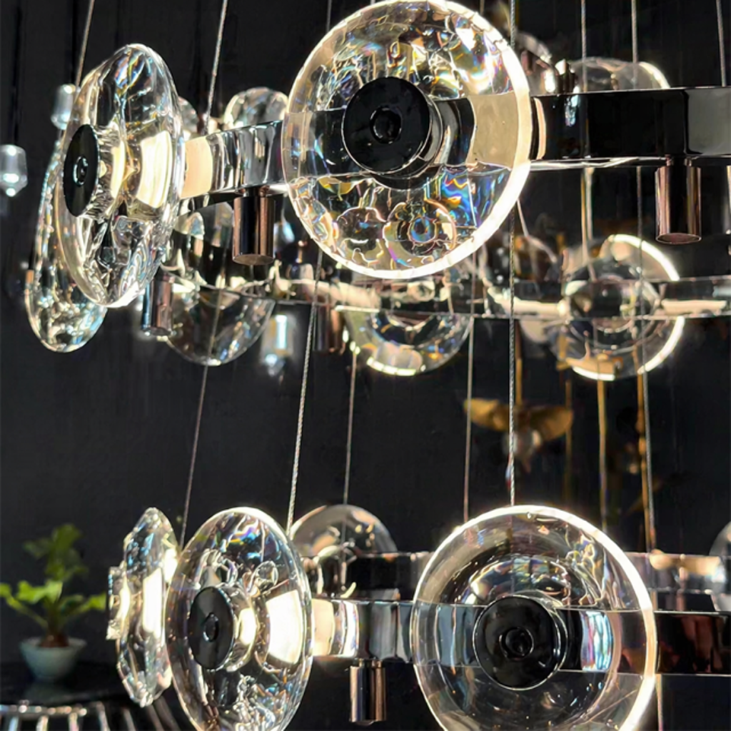 Close-up of thick optical crystal lens disc with halo LED lighting on a mirror chrome ring chandelier