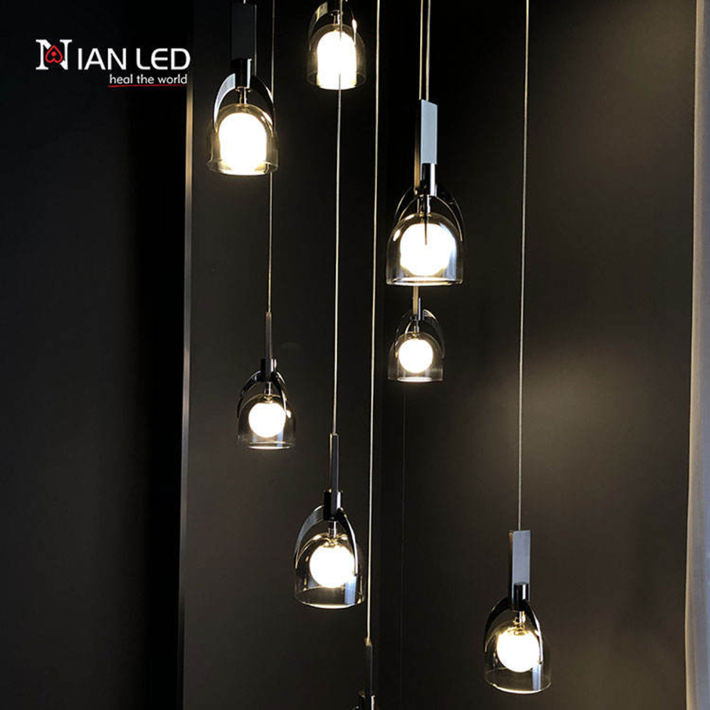 Close-up of double-layer glass shade, marble block, and mirror brown stainless steel arch frame on a luxury pendant chandelier