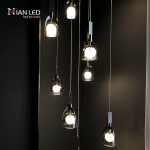 Close-up of double-layer glass shade, marble block, and mirror brown stainless steel arch frame on a luxury pendant chandelier