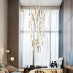 Modern gold polished stainless steel wave streamer raindrop chandelier suspended in a high ceiling villa foyer