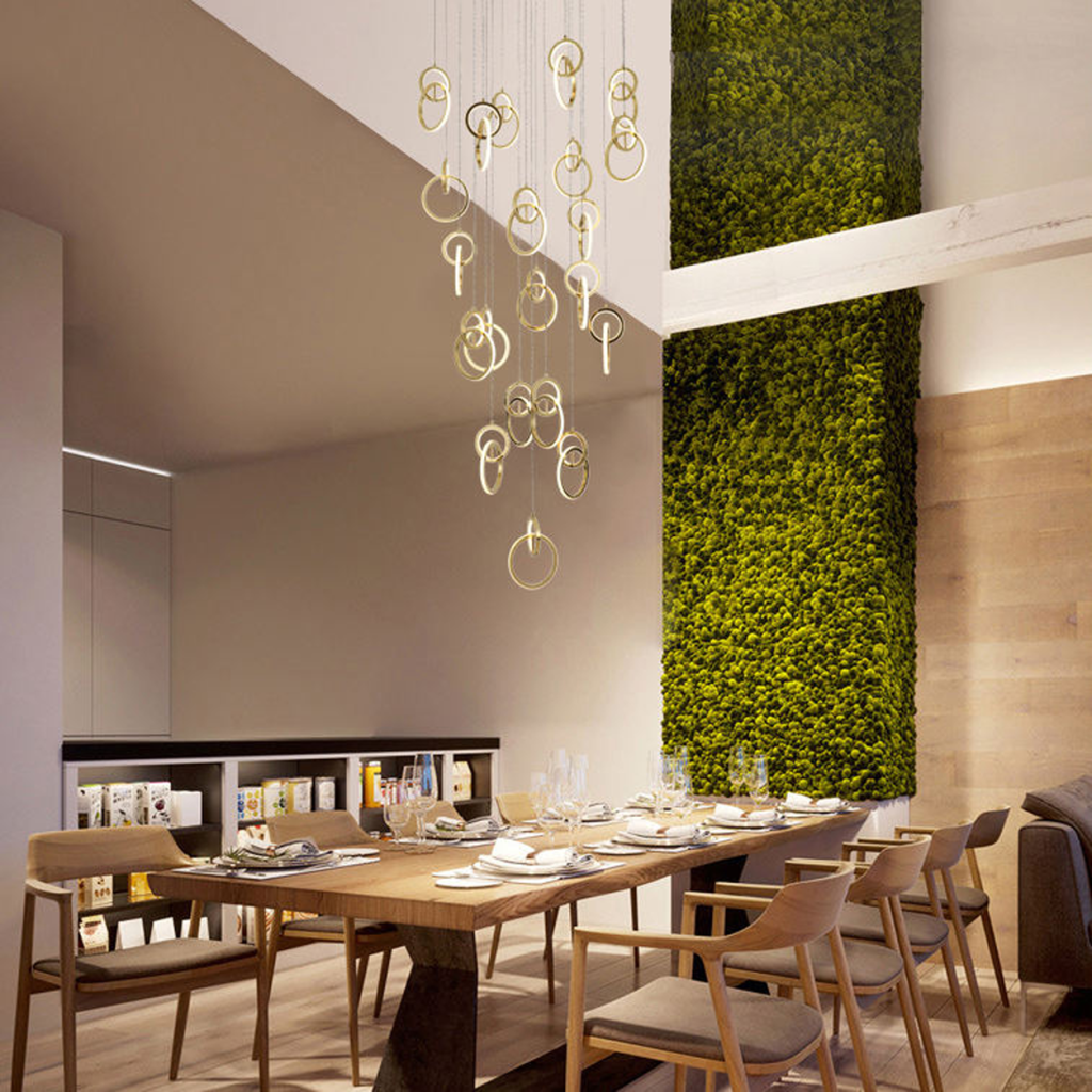 Modern gold stainless steel interlocking ring cascade chandelier suspended in a high ceiling villa foyer