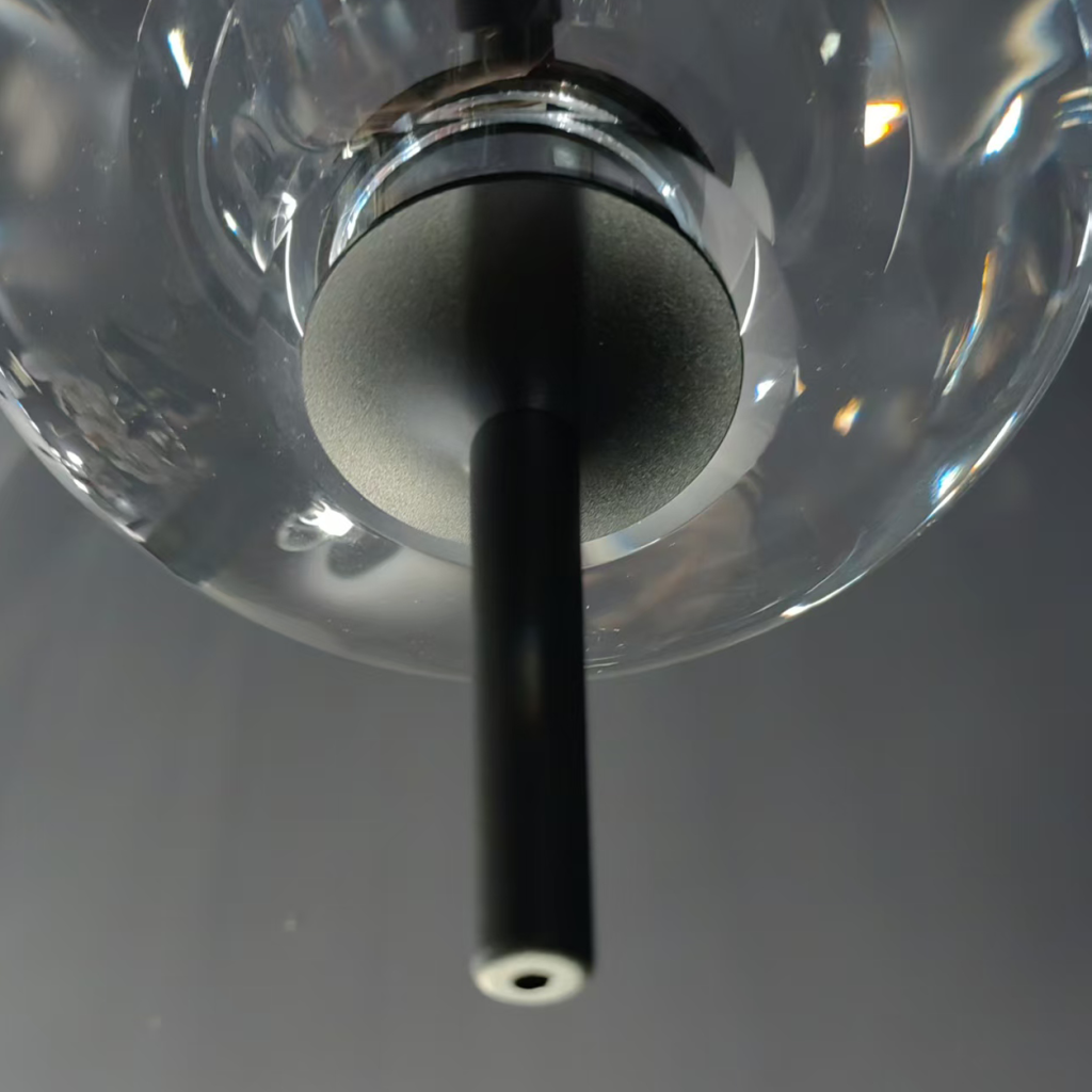 Close-up of UFO spinning-top crystal pendant light featuring optical crystal disc and matte black aluminum stem