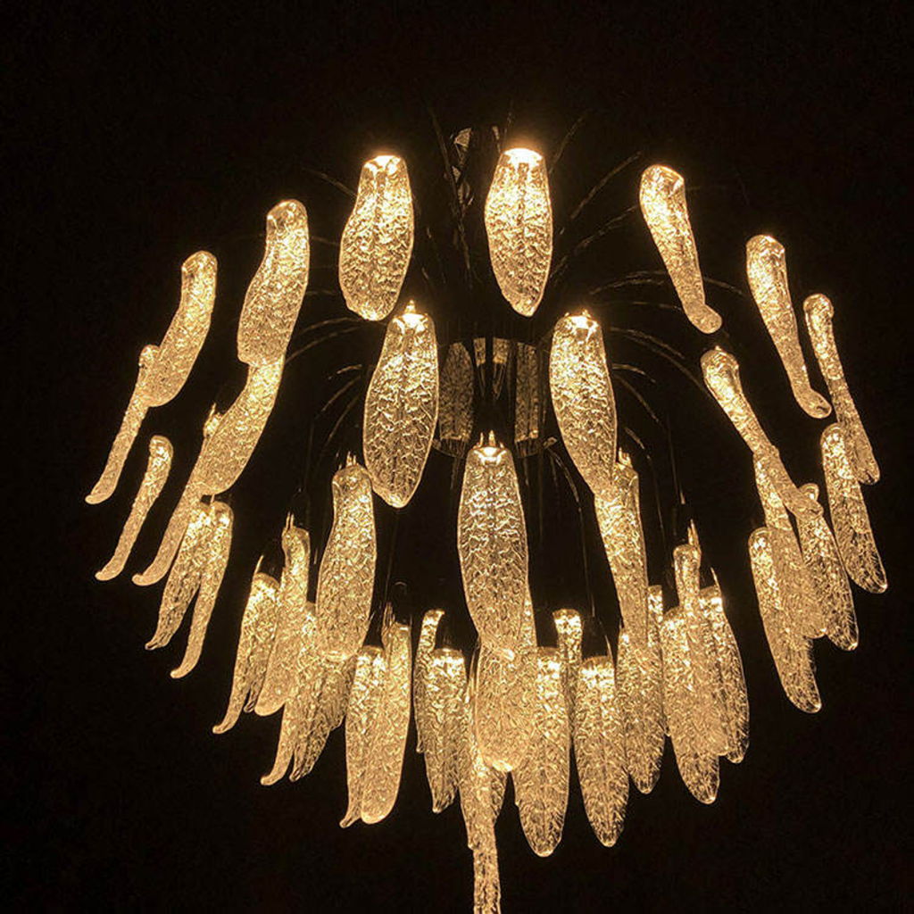 Illuminated optical acrylic cascade chandelier casting warm ambient light for high ceiling living room and foyer