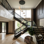 Modern spiral pebble optical acrylic staircase chandelier cascading down a high ceiling foyer