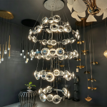 Close-up of thick optical crystal lens disc with halo LED lighting on a mirror chrome ring chandelier