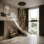 Modern gold polished stainless steel wave streamer raindrop chandelier suspended in a high ceiling villa foyer