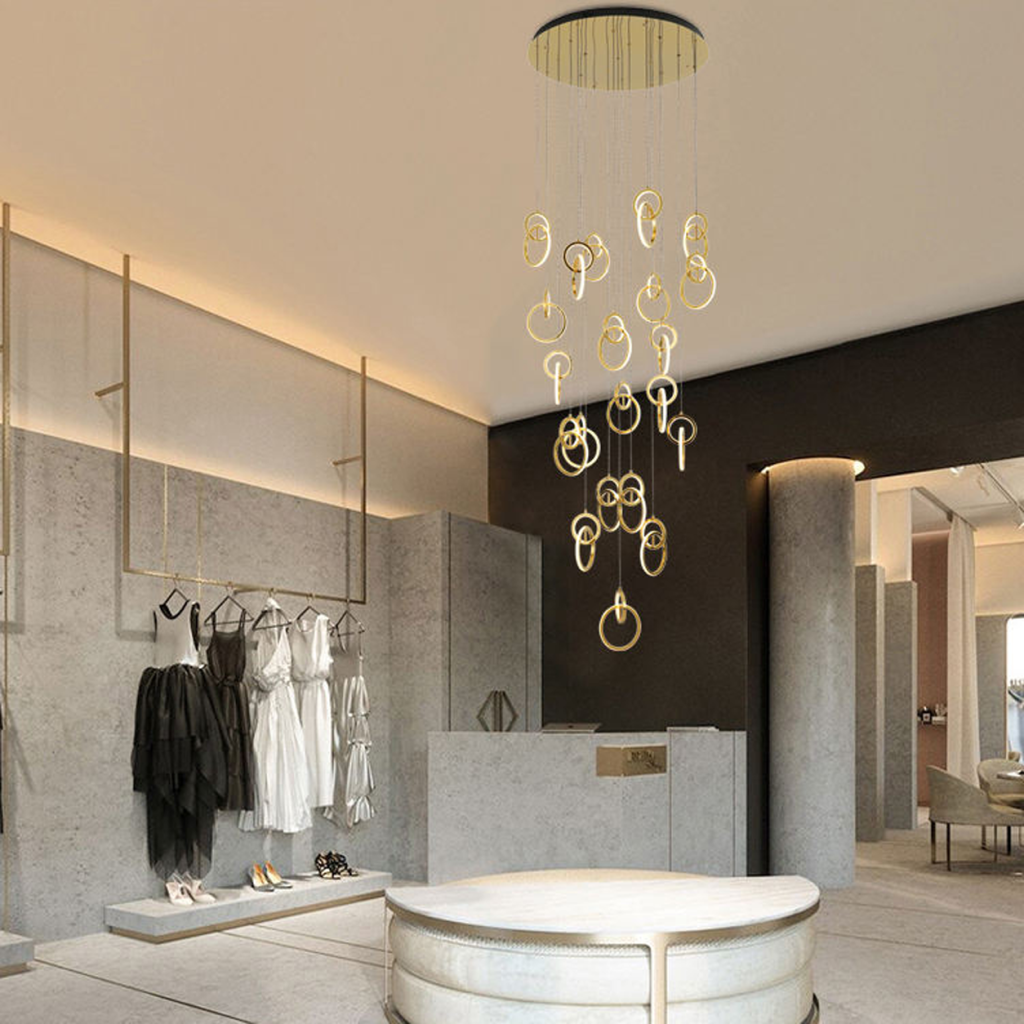 Modern gold stainless steel interlocking ring cascade chandelier suspended in a high ceiling villa foyer