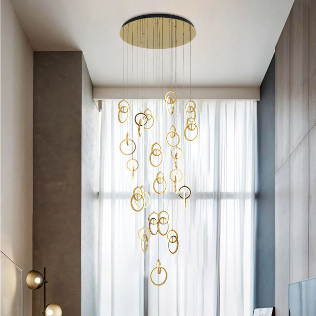 Modern gold stainless steel interlocking ring cascade chandelier suspended in a high ceiling villa foyer