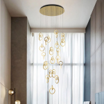 Modern gold stainless steel interlocking ring cascade chandelier suspended in a high ceiling villa foyer