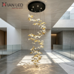 Tall spiral stainless steel and flying bird crystal cascade chandelier installed in a high-ceiling duplex villa stairwell