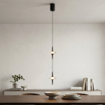 Two staggered black aluminum ufo crystal pendant lights hanging gracefully over a modern wooden dining table