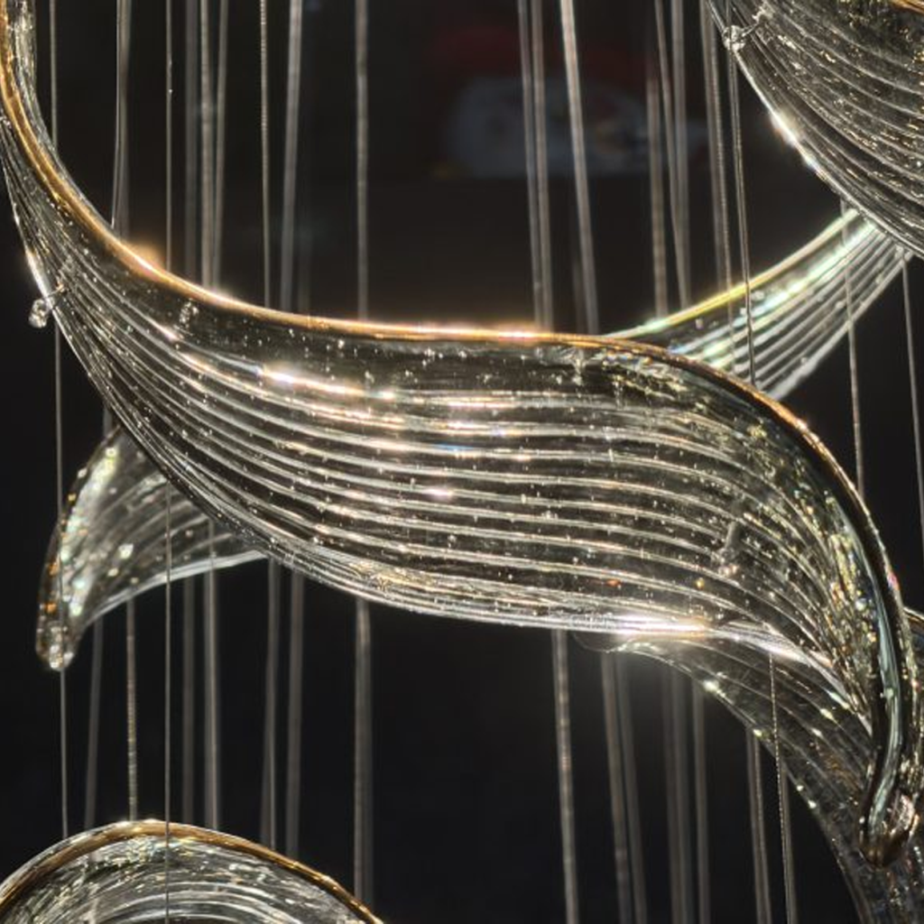 Close-up of golden curved textured art glass blades on a mirror stainless steel flush mount canopy