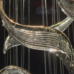 Close-up of golden curved textured art glass blades on a mirror stainless steel flush mount canopy