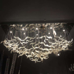 Illuminated 2400mm floating wave glass chandelier casting warm 3000K ambient glow for luxury hotel lobby