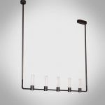 The Atelier matte black rectangular linear chandelier hanging over a wooden dining table in a luxury apartment