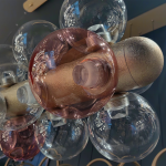 End view of blush pink and clear glass globes attached to crackle gold textured aluminum beamEnd view of blush pink and clear glass globes attached to crackle gold textured aluminum beam