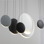 Close-up of matte grey, black, and white polyresin disc light shades showing crescent LED illumination and metal suspension cords