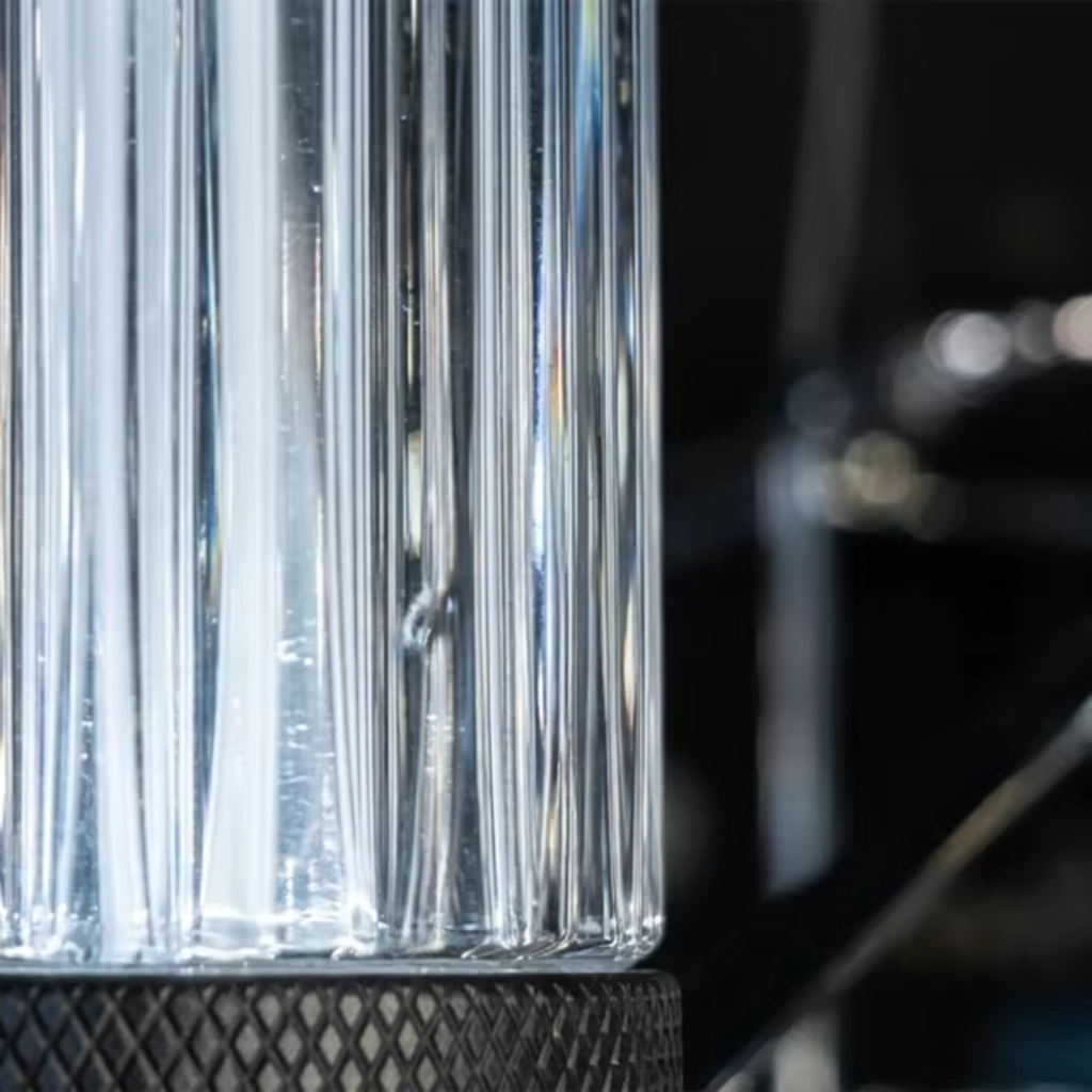 Macro view of high translucency ribbed clear glass column showing light refraction