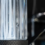 Macro view of high translucency ribbed clear glass column showing light refraction