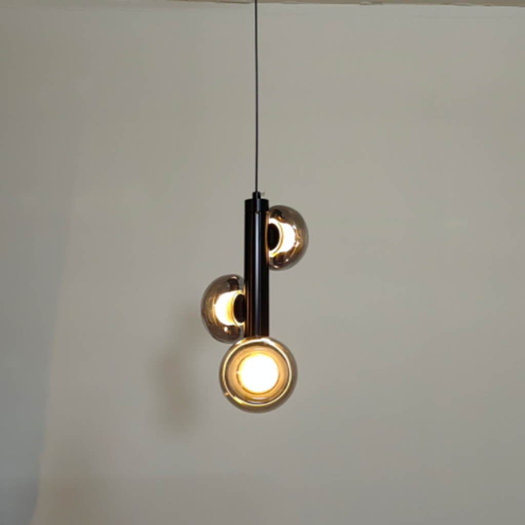 The Stellar mini pendant chandelier featuring three smoky glass orb shades on vertical black column