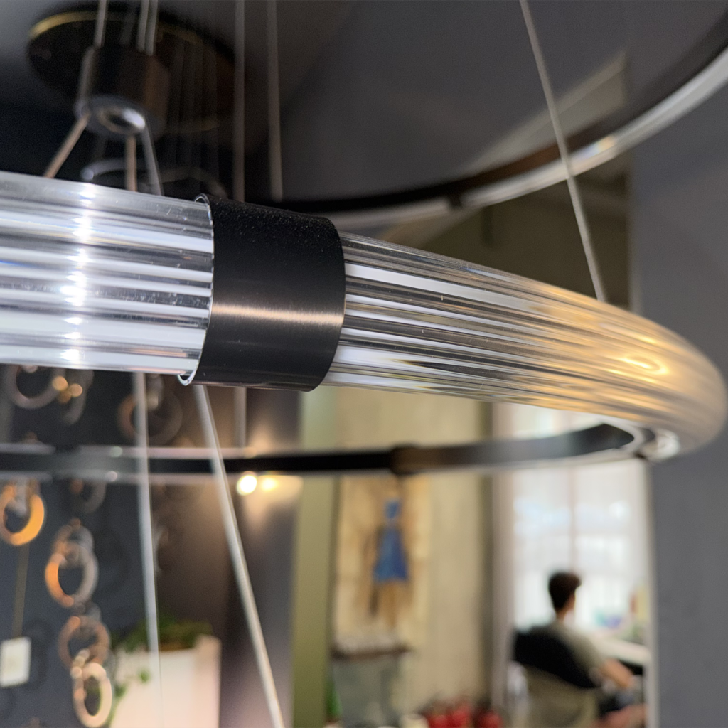 Close up of ribbed fluted acrylic halo diffuser joined by matte black metal clip