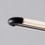 Close up of smooth curved matte black metal end cap connected to fluted acrylic cylinder