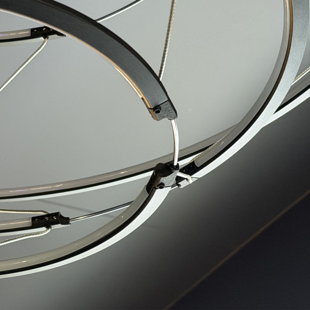 Close up view of matte black aluminum ring chandelier connected with stainless steel tension cables