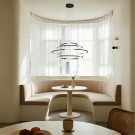 The Orbital Mesh multi tier LED ring chandelier hanging over a round dining table in a modern sunroom nook