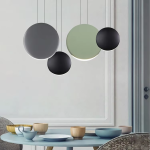 Close-up of matte grey, black, and white polyresin disc light shades showing crescent LED illumination and metal suspension cords