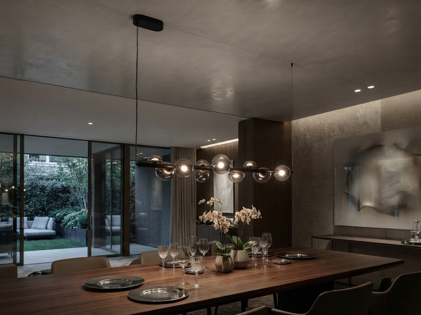The Constellation smoky glass sphere linear chandelier hanging over a modern marble reception desk