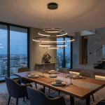 The Orbital Mesh multi tier LED ring chandelier hanging over a round dining table in a modern sunroom nook