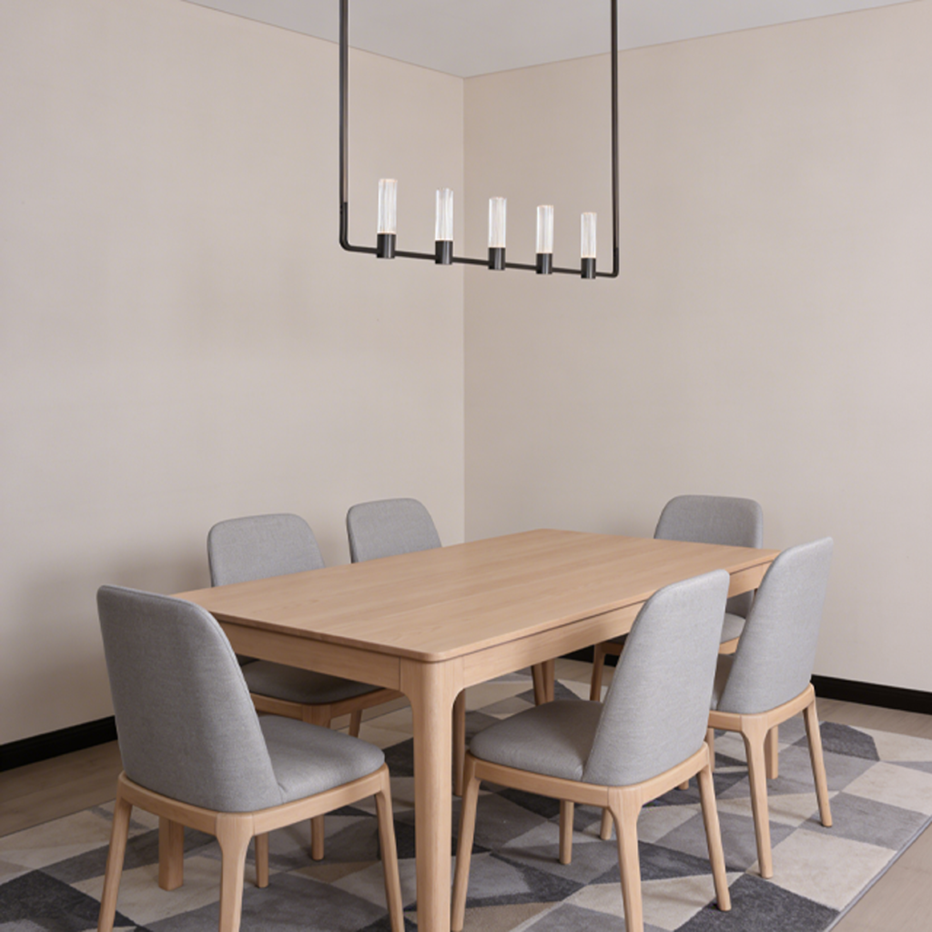 The Atelier matte black rectangular linear chandelier hanging over a wooden dining table in a luxury apartment