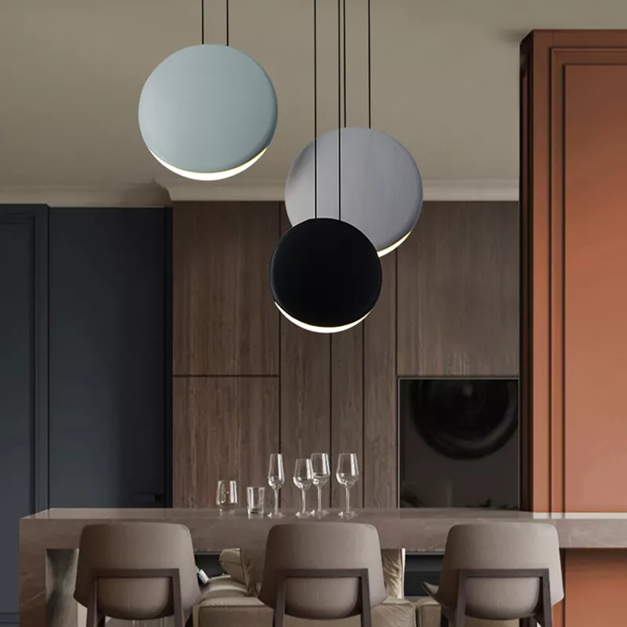Close-up of matte grey, black, and white polyresin disc light shades showing crescent LED illumination and metal suspension cords