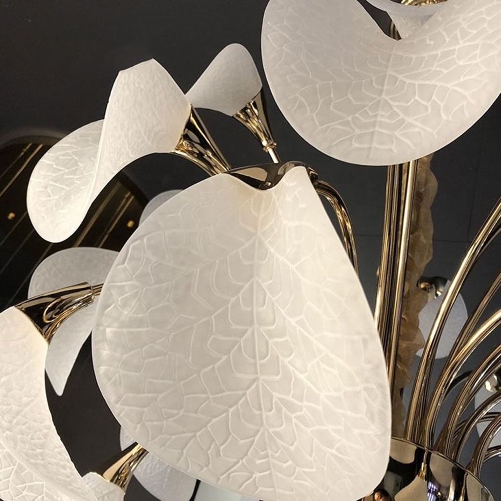 Detailed close-up of frosted optical acrylic leaf shade with etched vein texture on polished gold zinc alloy stem