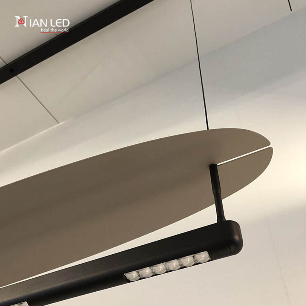 Close-up of sleek sandblasted aluminum surfboard reflector wing attached to a black aluminum connector arm