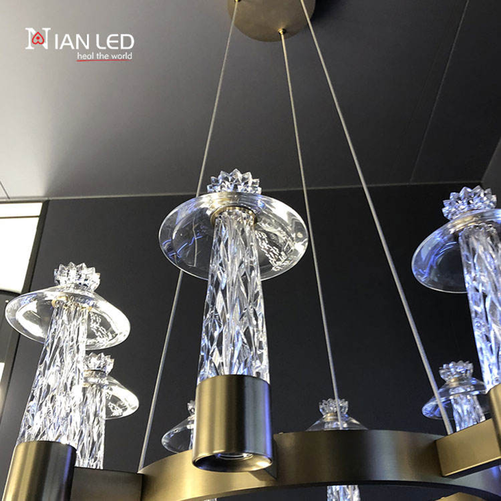 Detailed close-up of glowing diamond-cut faceted crystal pillar with saucer shade on brushed bronze stainless steel ring