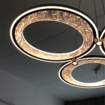 Warm glowing champagne gold aluminum ring light showing glittering crushed-ice textured pattern and downward aluminum spotlight node