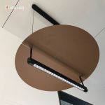 Bottom view of eclipse disc linear pendant showing precision-aligned lenses on black aluminum tube and bronze aluminum disc