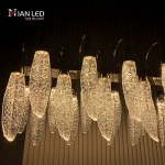 Side angle view of linear steel chandelier frame showing zinc alloy curved suspension hooks and frosted acrylic feather diffusers