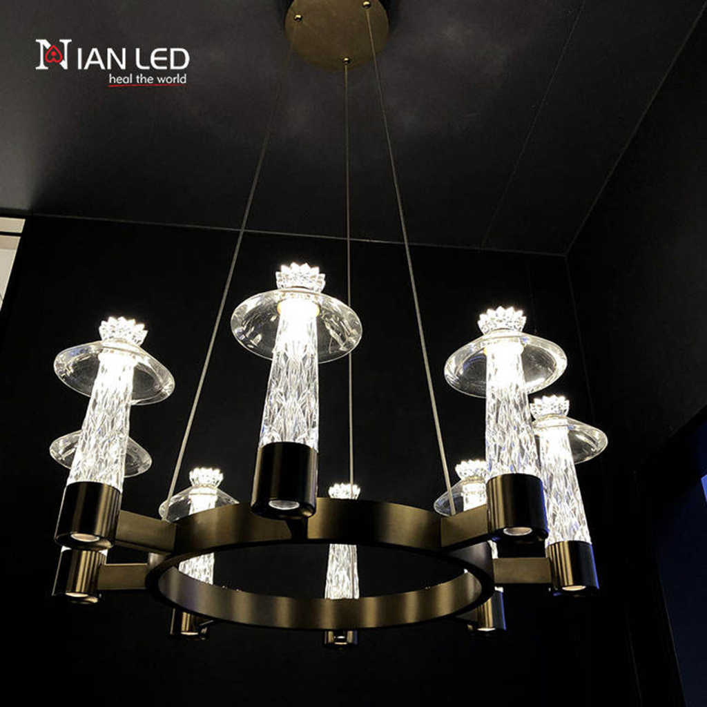 Glowing modern carved crystal ring chandelier with candle-like crystal shades shown against dark background